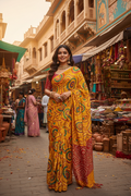 Indian woman wearing a vibrant yellow and red Bandhani saree in a Rajasthani street market